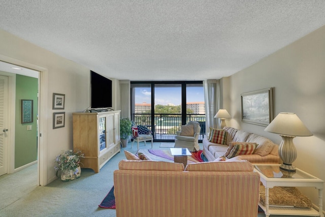 living room featuring light carpet, a textured ceiling, and a wall of windows