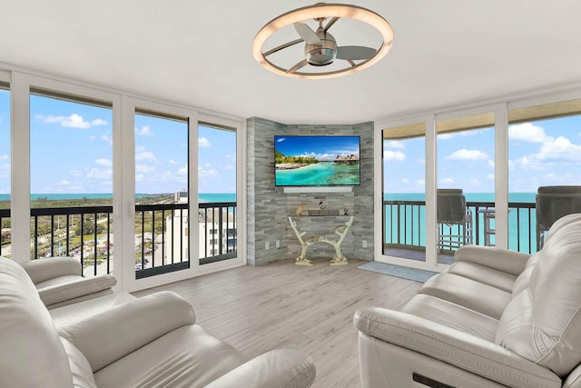 living room with expansive windows, a healthy amount of sunlight, and light hardwood / wood-style floors