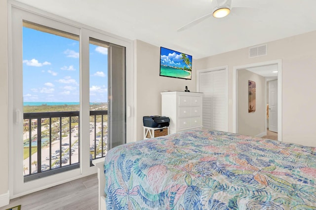 bedroom featuring access to exterior, light hardwood / wood-style flooring, a closet, and ceiling fan