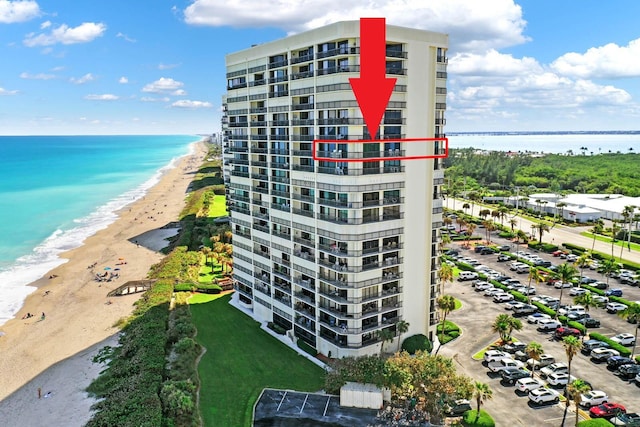 view of building exterior with a water view and a beach view