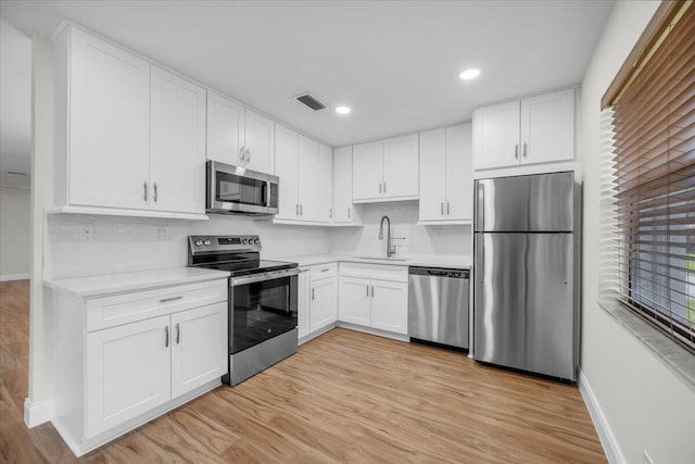 1714 Palmland Dr Unit 1714, Boynton Beach, FL 33436 - kitchen featuring appliances with stainless steel finishes, a sink, baseboards, light countertops, and recessed lighting
