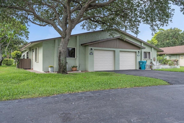 1714 Palmland Dr Unit 1714, Boynton Beach, FL 33436 - view of front of home with an attached garage, asphalt driveway, stucco siding, and a front yard