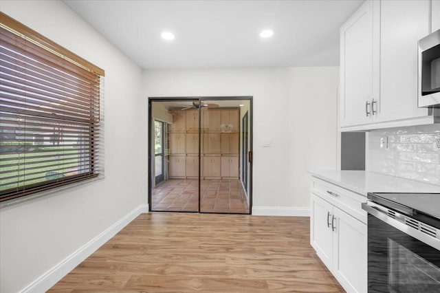 1714 Palmland Dr Unit 1714, Boynton Beach, FL 33436 - kitchen featuring stainless steel appliances, white cabinets, decorative backsplash, light wood-type flooring, and recessed lighting