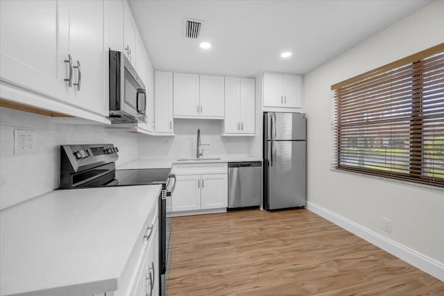 1714 Palmland Dr Unit 1714, Boynton Beach, FL 33436 - kitchen featuring stainless steel appliances, a sink, white cabinets, light countertops, and tasteful backsplash