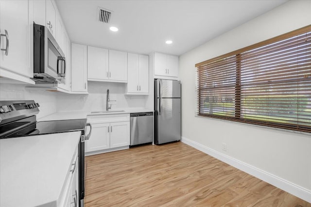 1714 Palmland Dr Unit 1714, Boynton Beach, FL 33436 - kitchen featuring stainless steel appliances, a sink, white cabinetry, baseboards, and light wood-type flooring