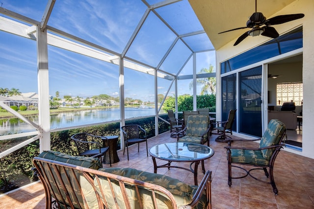 sunroom with a water view and ceiling fan