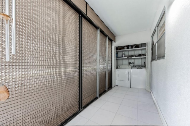 corridor featuring light tile patterned flooring, washer and clothes dryer, and baseboards