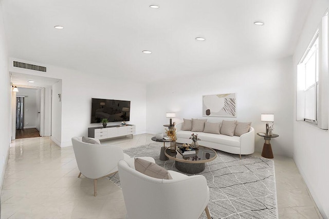 living area with baseboards, visible vents, and recessed lighting