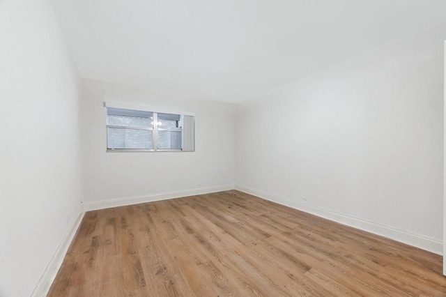 empty room with light wood finished floors and baseboards