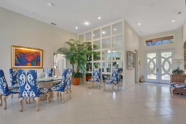 dining space featuring light tile patterned floors, visible vents, a towering ceiling, french doors, and recessed lighting