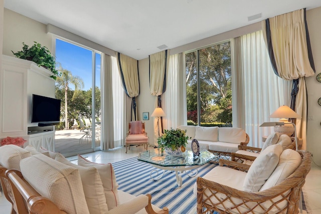 living area with light tile patterned floors, visible vents, and a wealth of natural light