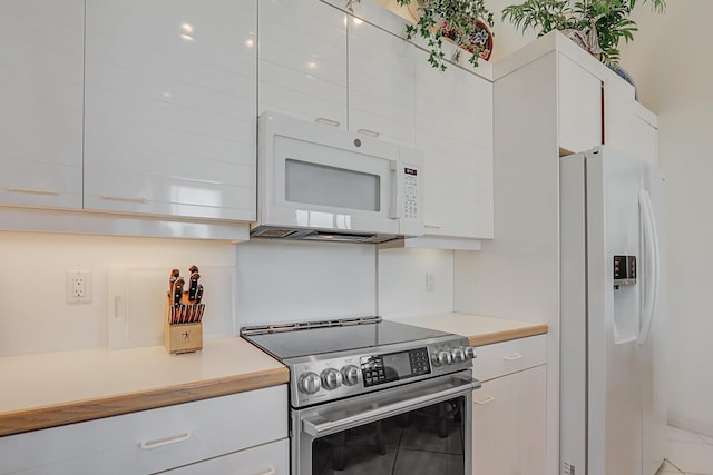 kitchen with light countertops, white appliances, and white cabinets