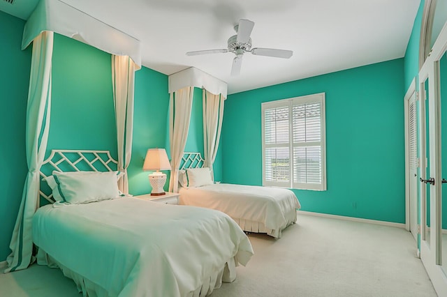 bedroom featuring a ceiling fan, light carpet, and baseboards