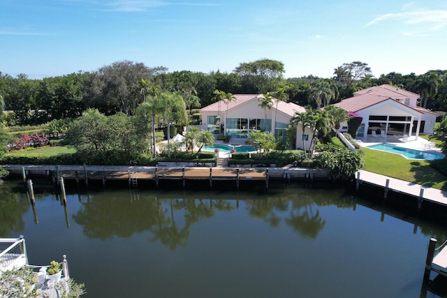 exterior space featuring a patio area, a water view, and an outdoor pool