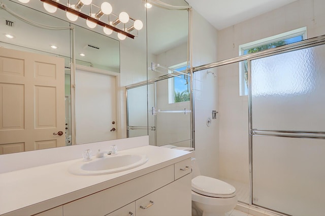 bathroom featuring vanity, toilet, and an enclosed shower