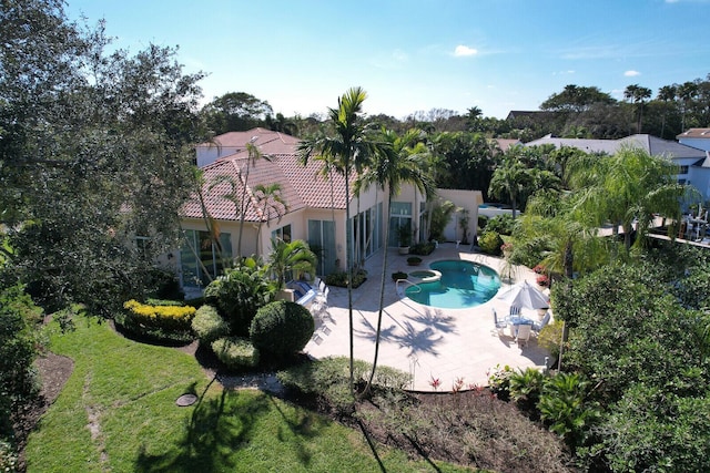 outdoor pool with a patio area and a lawn