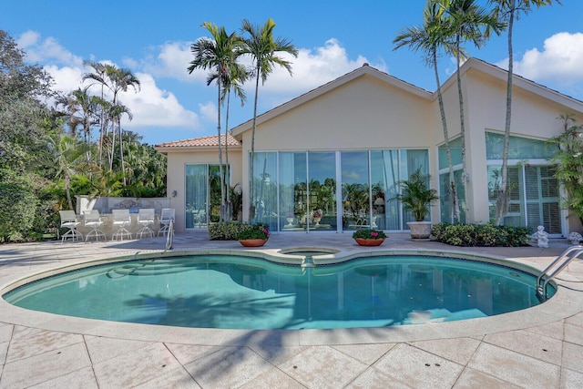 pool featuring a patio and an in ground hot tub