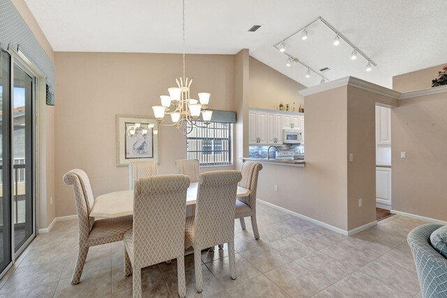 kitchen featuring sink, white cabinets, a chandelier, hanging light fixtures, and white appliances