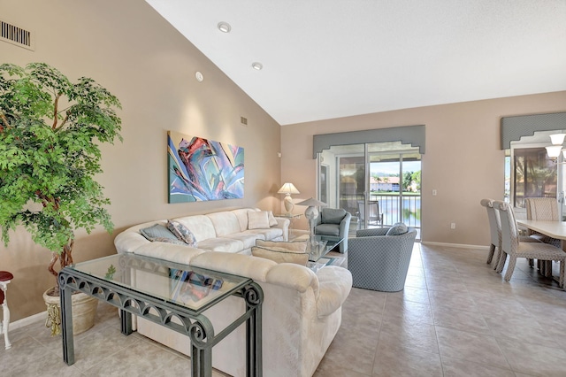 living area featuring light tile patterned flooring, baseboards, visible vents, and high vaulted ceiling