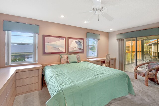 carpeted bedroom featuring ceiling fan, built in desk, and multiple windows