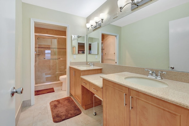 bathroom featuring tile patterned floors, toilet, a shower with shower door, and vanity