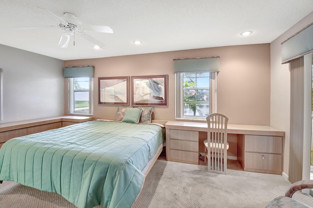 bedroom featuring recessed lighting, multiple windows, a ceiling fan, and built in desk