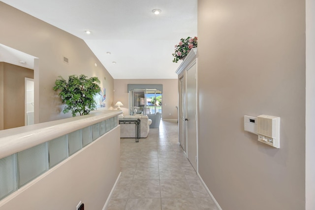 hall featuring lofted ceiling and light tile patterned floors