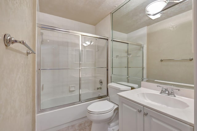 full bathroom with vanity, toilet, tile patterned flooring, and combined bath / shower with glass door