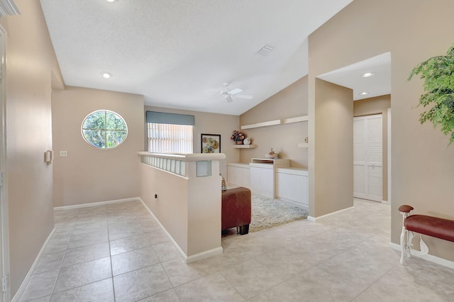 entrance foyer featuring baseboards, ceiling fan, vaulted ceiling, light tile patterned floors, and a textured ceiling