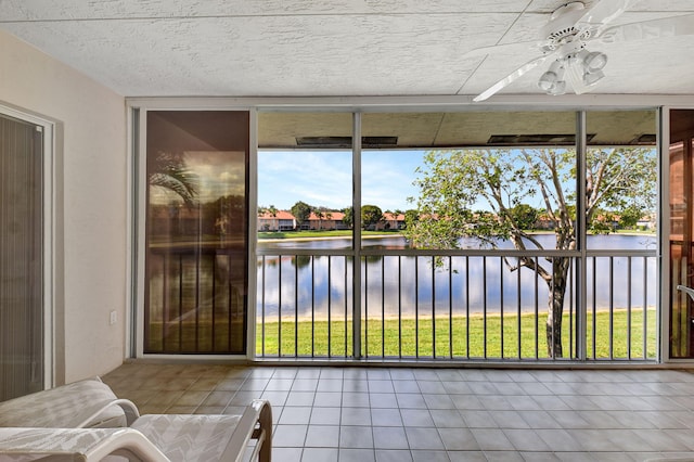 sunroom / solarium featuring a water view and ceiling fan