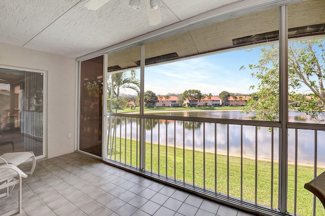 unfurnished sunroom featuring a water view and ceiling fan