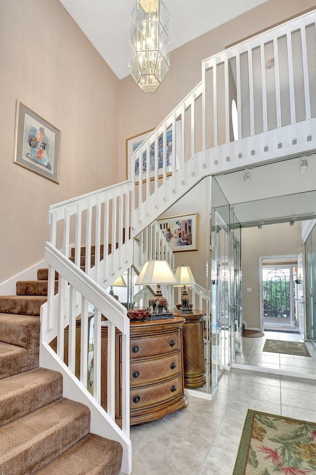 stairs featuring a notable chandelier and a high ceiling