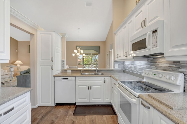 kitchen featuring white appliances, a sink, white cabinetry, a notable chandelier, and tasteful backsplash