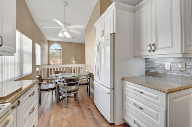 kitchen with tasteful backsplash, light stone countertops, white refrigerator with ice dispenser, light wood-style floors, and white cabinets