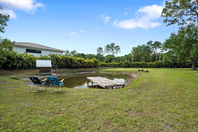 view of dock with a water view and a lawn