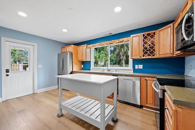 kitchen featuring appliances with stainless steel finishes, light hardwood / wood-style floors, and sink