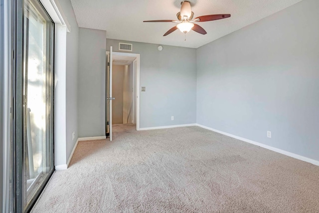 carpeted spare room with a textured ceiling and ceiling fan