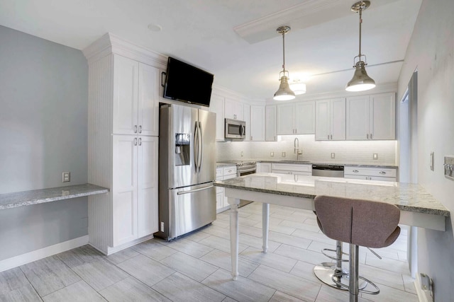 kitchen with light stone counters, white cabinetry, stainless steel appliances, and decorative light fixtures