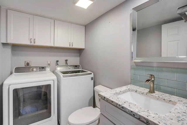 bathroom featuring vanity, toilet, separate washer and dryer, and decorative backsplash