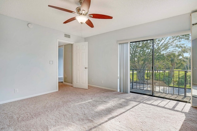 interior space with carpet, ceiling fan, and a textured ceiling