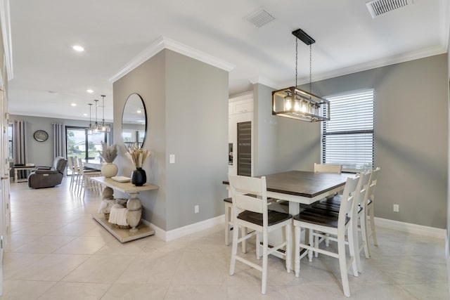 dining room featuring an inviting chandelier, light tile patterned floors, and crown molding