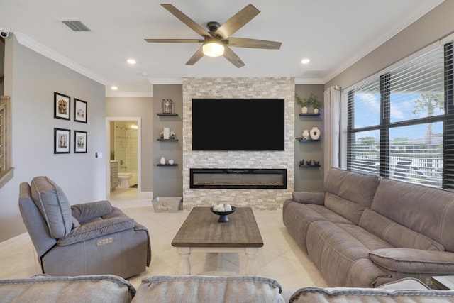 tiled living room featuring ceiling fan, ornamental molding, and a fireplace