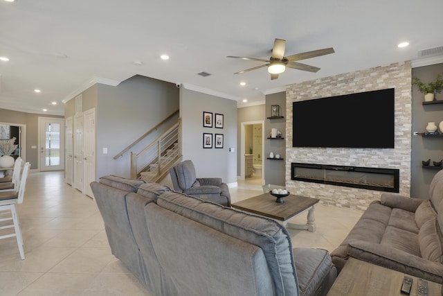 living room with light tile patterned flooring, ornamental molding, and a fireplace