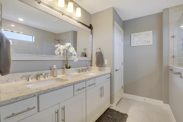 bathroom with vanity, tile patterned flooring, and a tile shower