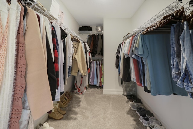 walk in closet featuring light carpet