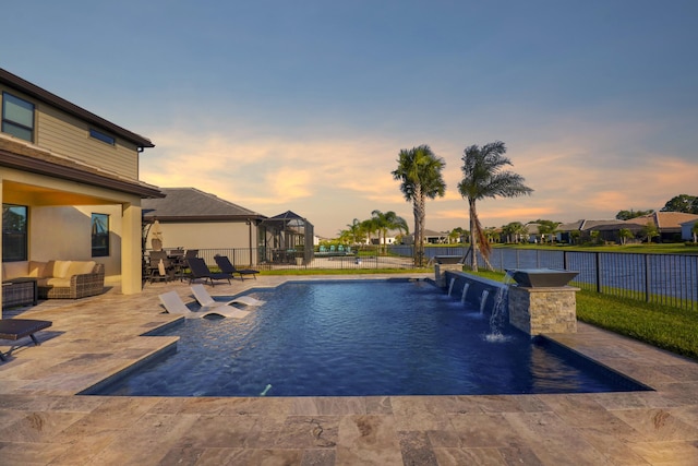 pool at dusk with a patio area, outdoor lounge area, pool water feature, and an outdoor bar