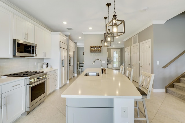 kitchen featuring stainless steel appliances, sink, a center island with sink, and white cabinets