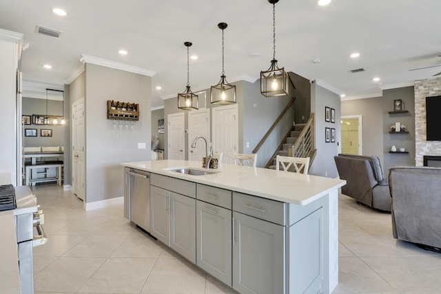 kitchen with sink, gray cabinets, an island with sink, pendant lighting, and stainless steel appliances