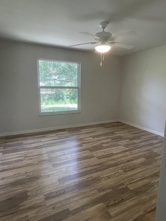 empty room with ceiling fan and dark hardwood / wood-style flooring