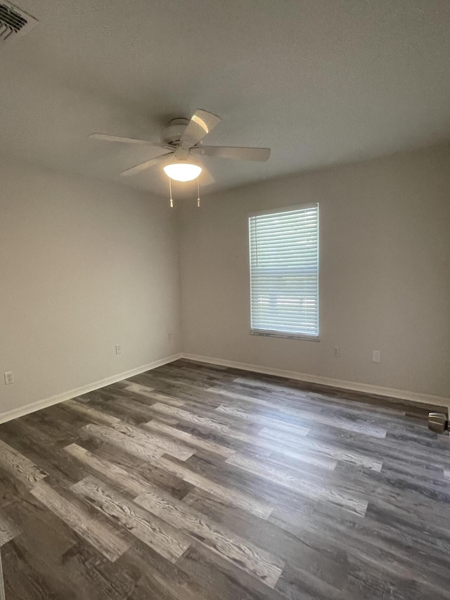 empty room featuring ceiling fan and dark hardwood / wood-style flooring